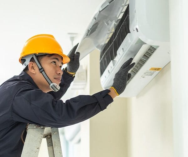 Technician Inspecting An Aircon Unit